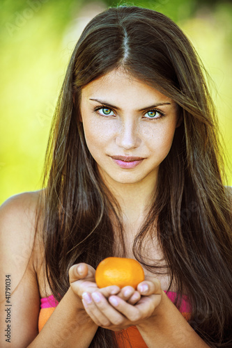 Photo: beautiful woman holding tangerine beautiful woman holding tangerine