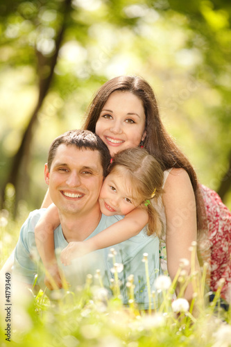 Photo: Happy mother, father and daughter in the park Happy mother, father and daughter in the park