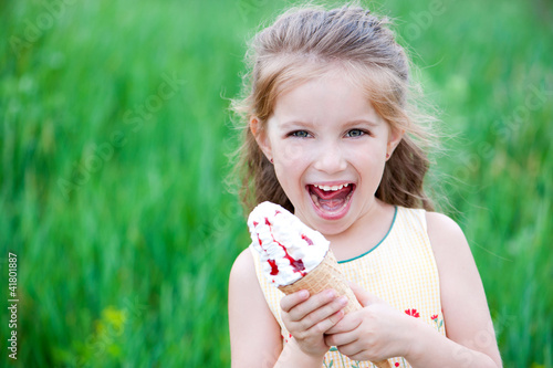 Photo: Beautiful little girl eats ice-cream Beautiful little girl eats ice-cream