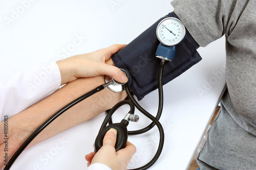 Photo: Doctor checking blood pressure with stethoscope and sphygmomanom Doctor checking blood pressure with stethoscope and sphygmomanom