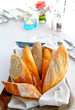 Sliced baguette with kitchenware on table Sliced baguette with kitchenware on table
