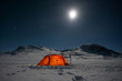 Moon over a illuminated Tent on a Winter Expedition