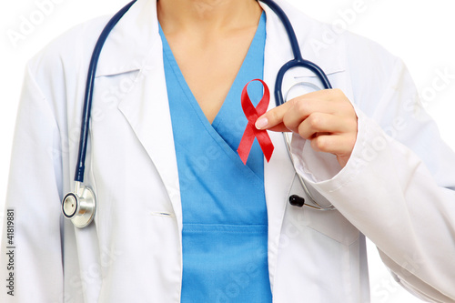 Photo: A female doctor holding a red ribbon as a symbol of AIDS A female doctor holding a red ribbon as a symbol of AIDS