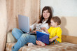 woman with toddler using laptops in living room woman with toddler using laptops in living room
