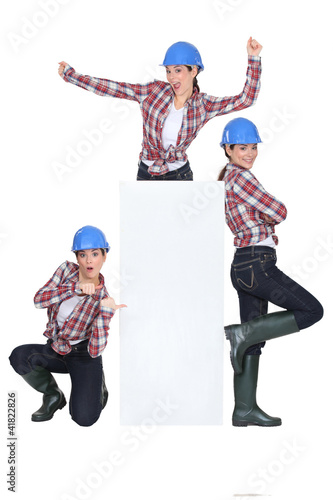Photo: Triplets dancing around a blank sign Triplets dancing around a blank sign