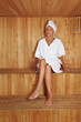 Ältere Frau sitzt in Sauna