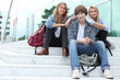 Three students sitting outside on some steps