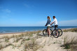 Couple with bicycles looking at the ocean