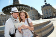 Couple standing by a fountain in Bordeaux with map