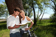 Couple on a bike ride making a stop to look at map