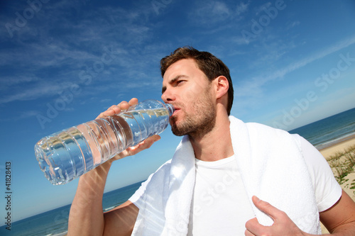 Foto: Portrait of jogger drinking water from bottle Portrait of jogger drinking water from bottle