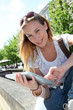 Blond woman in town using electronic tablet Blond woman in town using electronic tablet
