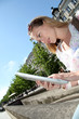 Blond woman in town using electronic tablet Blond woman in town using electronic tablet