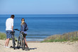 Couple with bicycles looking at the ocean