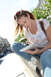 Blond woman in town using electronic tablet Blond woman in town using electronic tablet