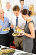 Business colleagues eat buffet appetizers