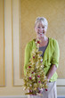 Photo: Senior woman with ornamental Christmas tree, smiling, portrait Senior woman with ornamental Christmas tree, smiling, portrait