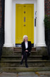 Beautiful young woman sat on steps in front of yellow door Beautiful young woman sat on steps in front of yellow door
