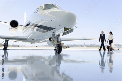 Photo: Two women walking towards aeroplane on runway Two women walking towards aeroplane on runway