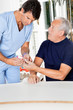Male Nurse Checking Sugar Level Of Senior Man Male Nurse Checking Sugar Level Of Senior Man