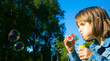 Little girl blowing soap bubbles