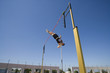 Photo: Male pole vault athlete going over bar, low angle view Male pole vault athlete going over bar, low angle view