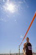 Photo: Young male athlete by bar, low angle view (lens flare) Young male athlete by bar, low angle view (lens flare)
