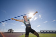 Photo: Male athlete preparing to throw javelin, low angle view (lens flare) Male athlete preparing to throw javelin, low angle view (lens flare)