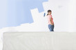 Smiling woman painting living room wall with paint roller