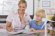 Foto: Curious student and teacher examining model wind turbine in school classroom Curious student and teacher examining model wind turbine in school classroom