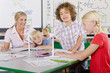 Foto: Curious students examining model wind turbine in school classroom Curious students examining model wind turbine in school classroom
