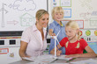 Foto: Curious students and teacher examining model wind turbine in school classroom Curious students and teacher examining model wind turbine in school classroom