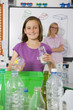 Smiling student putting glass into recycling bin