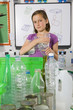 Serious student putting glass into recycling bin