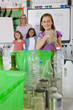 Teacher and students sorting recyclables in classroom together