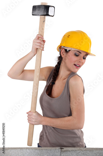 Foto: Tradeswoman using a mallet to hit stones Tradeswoman using a mallet to hit stones