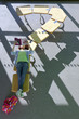 Photo: Student laying on row of school desks formed into a question mark symbol studying Student laying on row of school desks formed into a question mark symbol studying