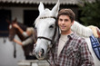 Young man looking after horses