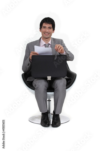 Foto: Man taking papers out his briefcase. Man taking papers out his briefcase.