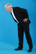 Man bending over to look at something on the floor