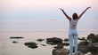 The woman on the seashore подымает hands up also stretches