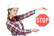 Female construction worker holding stop sign