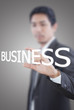 Businessman holding Business word on the whiteboard.
