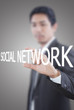 Businessman holding Social Network word on the whiteboard.