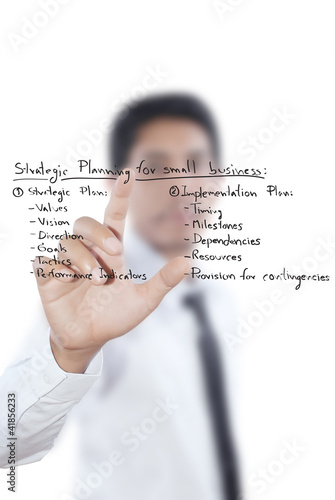 Photo: Businessman pushing strategic planning on the whiteboard. Businessman pushing strategic planning on the whiteboard.
