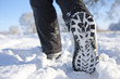 Close up of woman's feet walking through field of snow