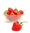 strawberries in a bowl and one of them is standing out