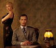 Man in suit  with woman behind him.