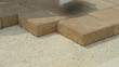 Worker laying brick tiles on the road