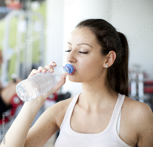 Photo: Girl drinking water in the gym Girl drinking water in the gym